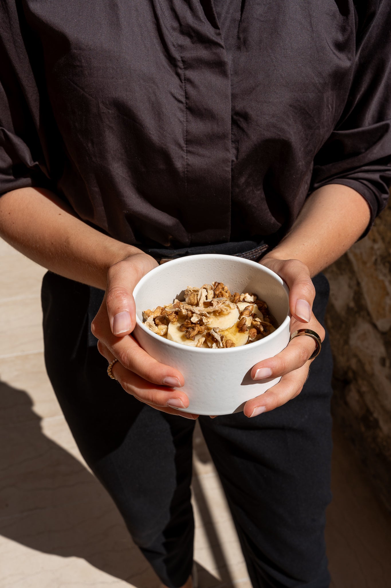 Eine Frau hält eine Yoghurt-Bowl mit Yacon Crunch von Soul Feed in den Händen.