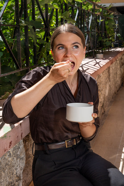 Eine Frau genießt den Bio Yacon Crunch von Soul Feed als Topping in einer Bowl.
